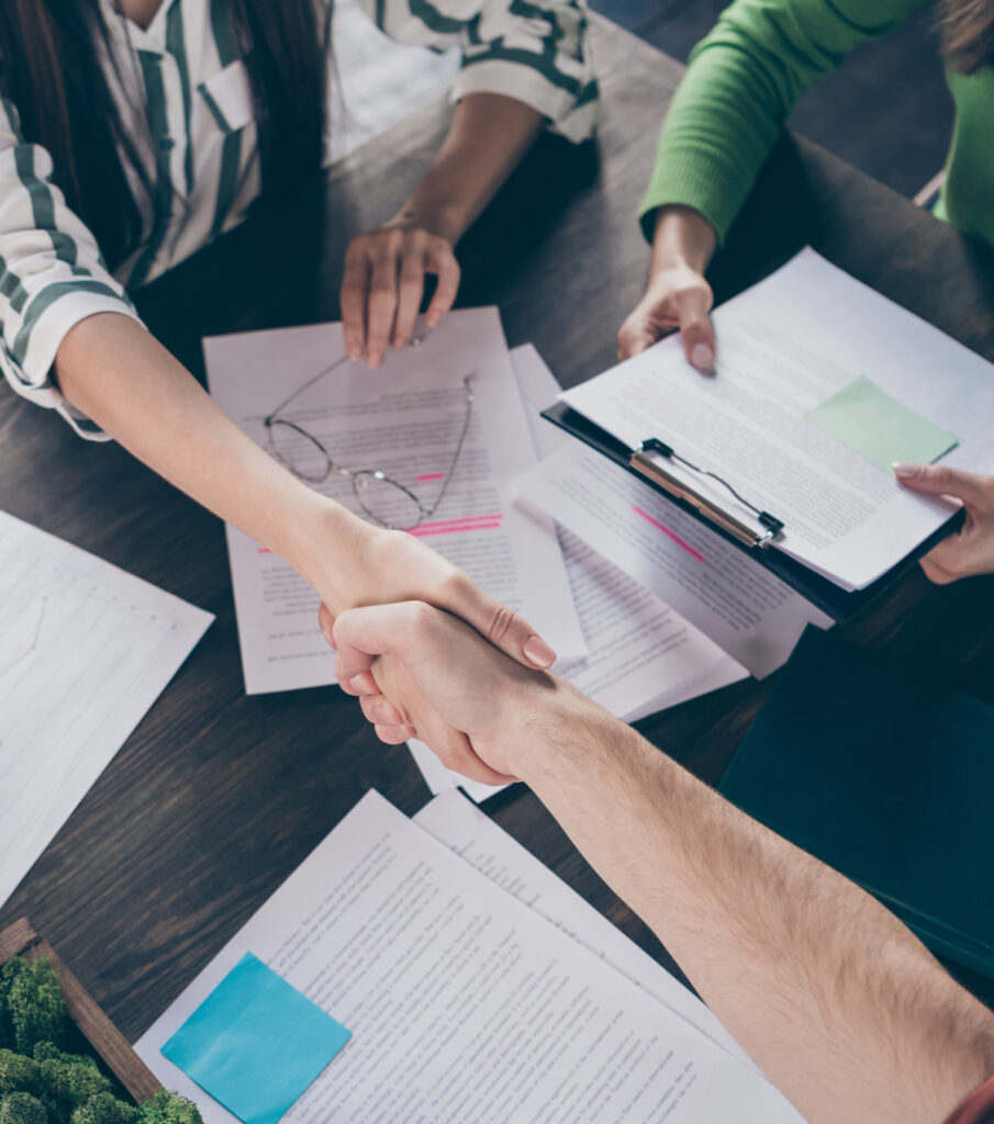 Photo of two business people at a table with a report representing technical due diligence for business brokers when negotiating a deal that includes business critical software assets.